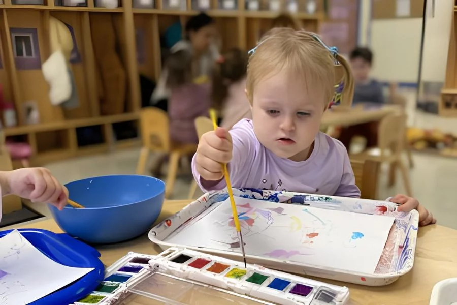 little girl painting at table
